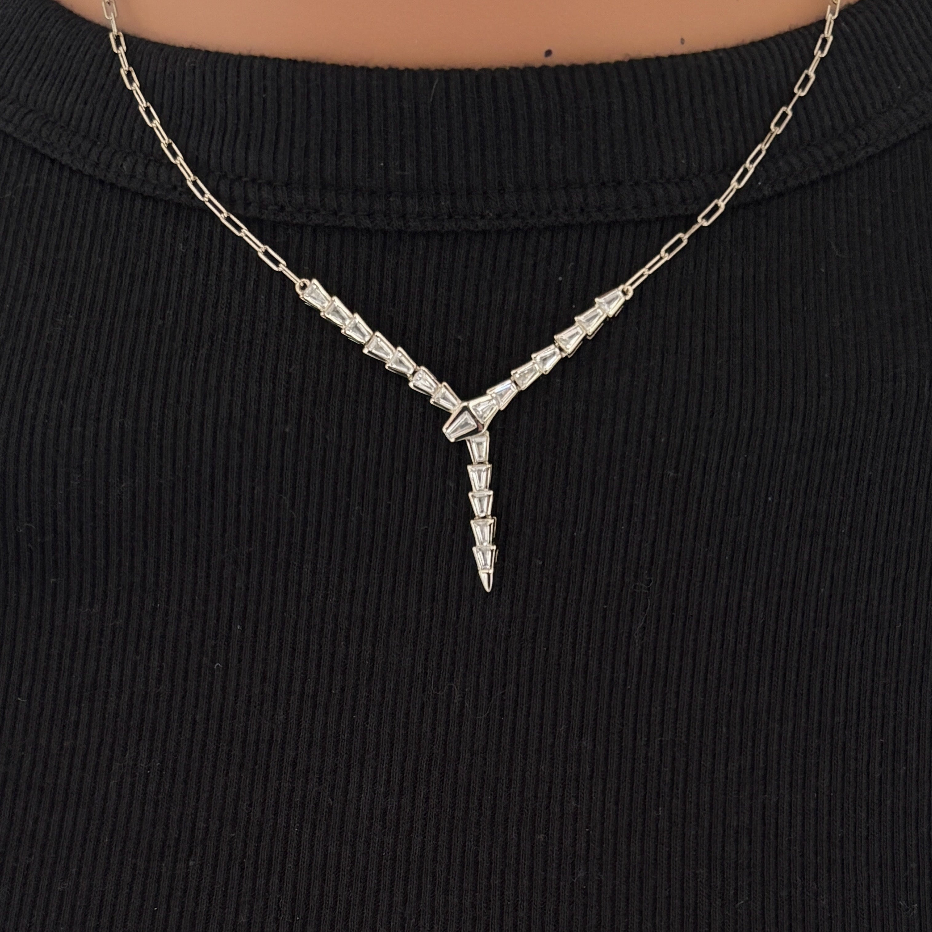 Close up view of the Baguette Snake Necklace in silver styled on a model highlighting the 925 sterling silver Y drop silhouette and baguette stone detailing