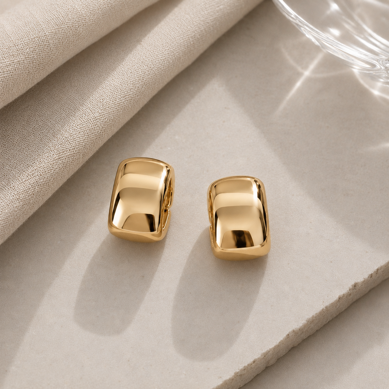 Luxxy Brookes Curved Stud Earrings in 14k gold with polished curved design on light gray background