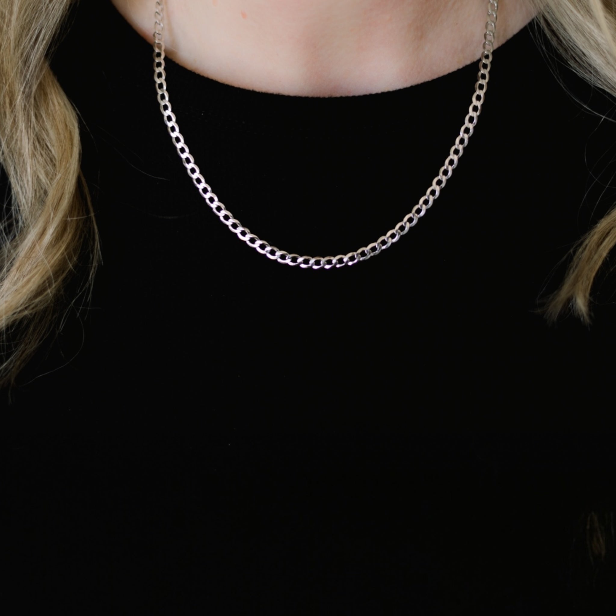 Model wearing Brynn Cuban Necklace in silver showing dainty flat Cuban chain design crafted in rhodium plated 925 sterling silver for elevated everyday Luxxy style