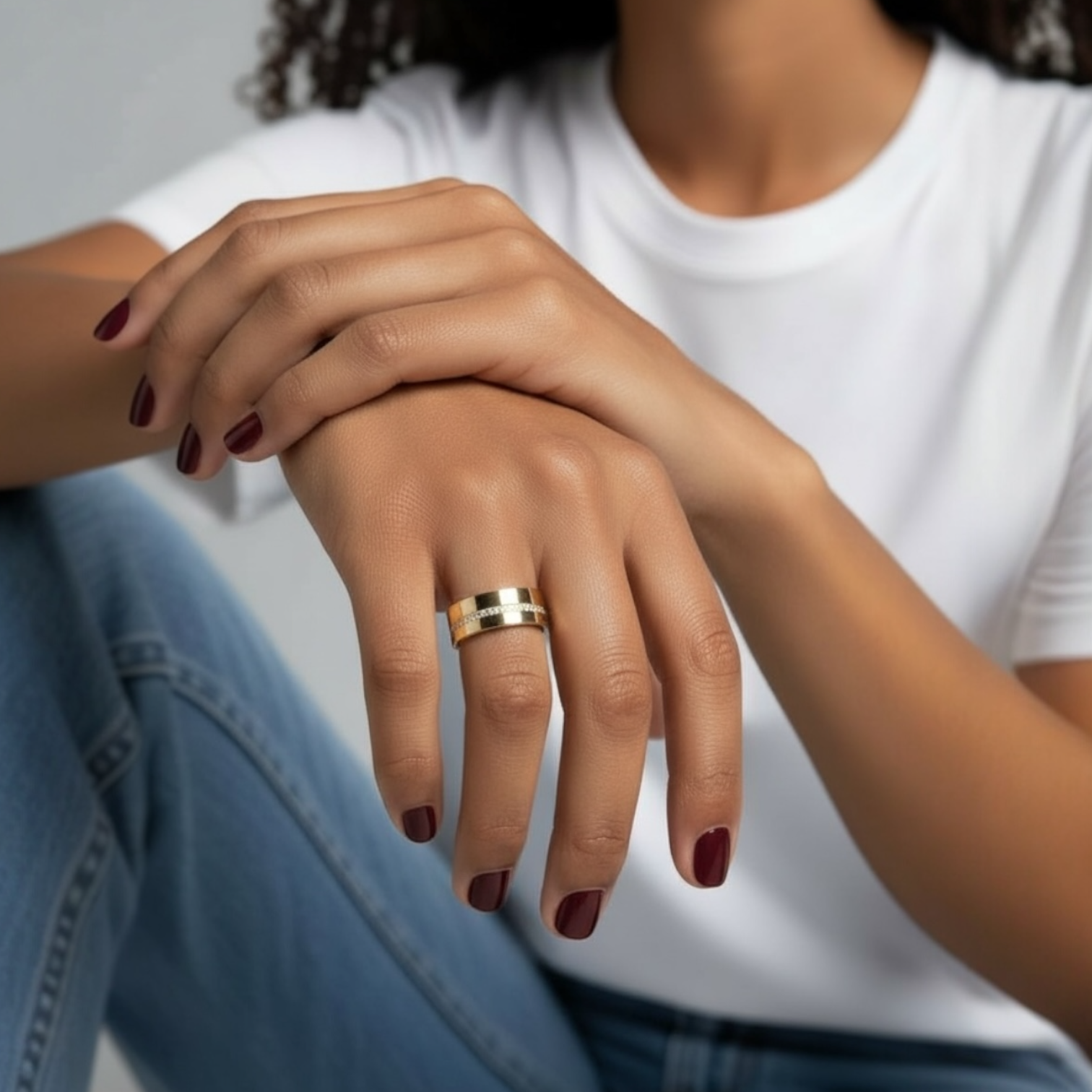 Close up of the Celine cigar ring worn on a model highlighting the bold gold band and pavé diamond center row