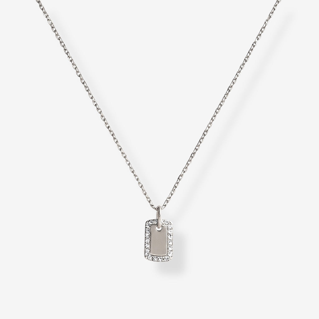 The Dainty Dog Tag Necklace in sterling silver features a rectangular pendant with micro pave simulated diamonds bordering a smooth center, shown on a white background.