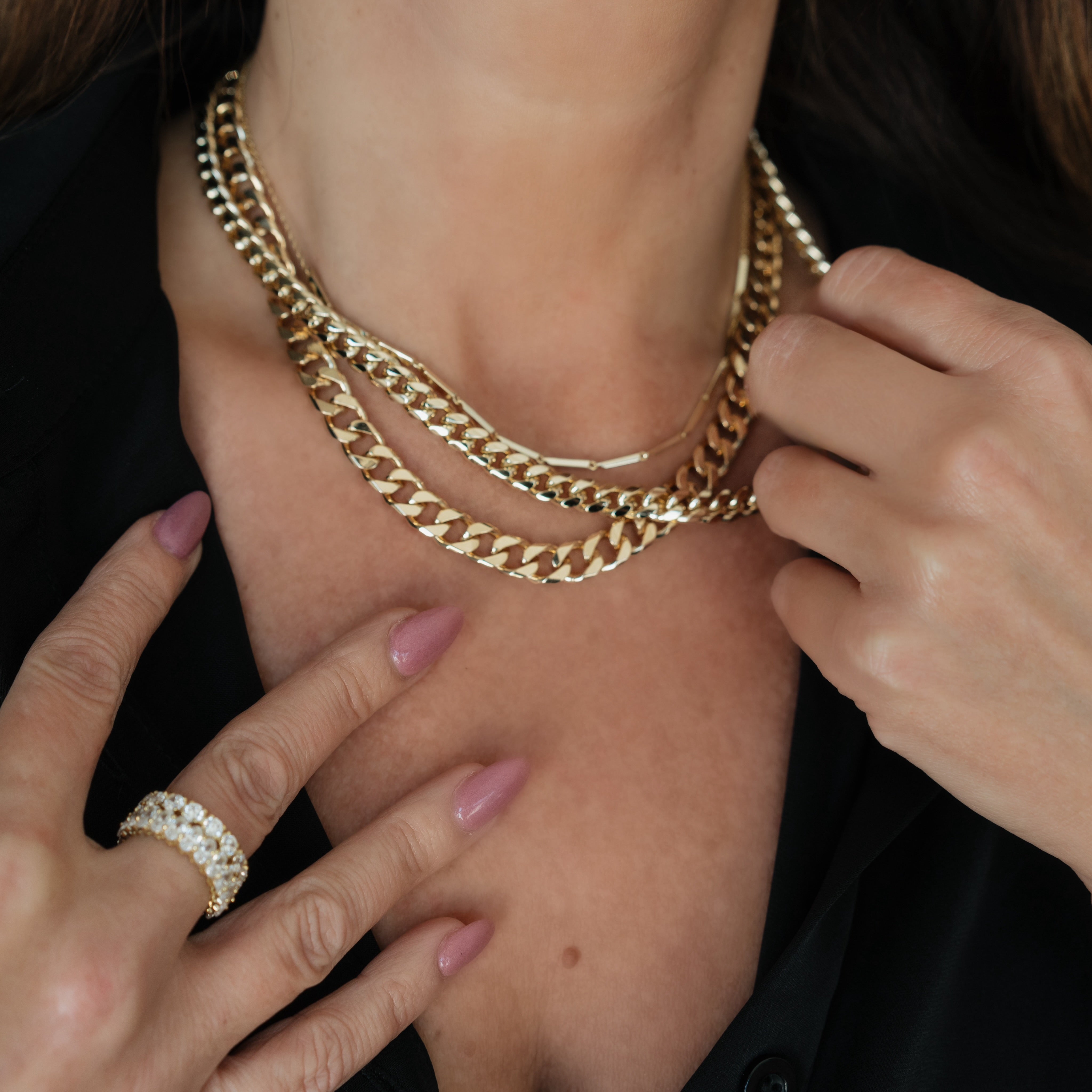 Woman wearing Luxxy Zoe Curb Chain in gold and simulated diamond eternity rings in gold