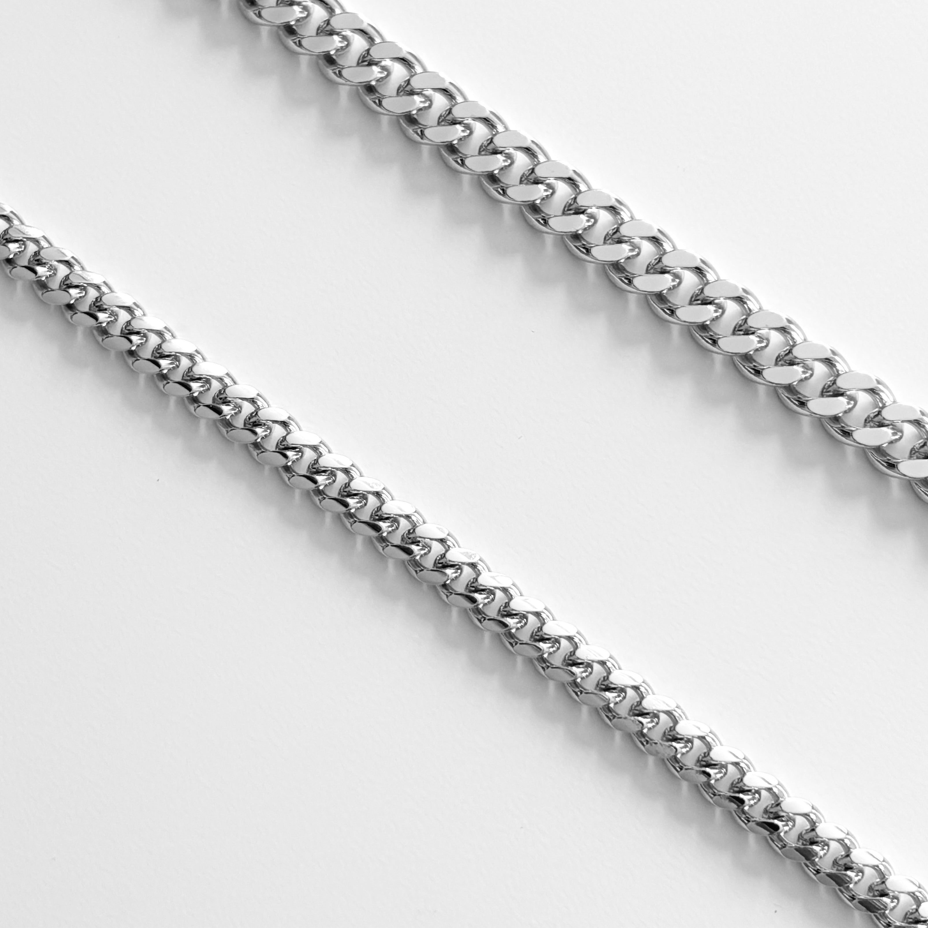 Luxxy close-up of two silver curb chain necklaces on a light gray background | Affordable luxury jewelry by Luxxy