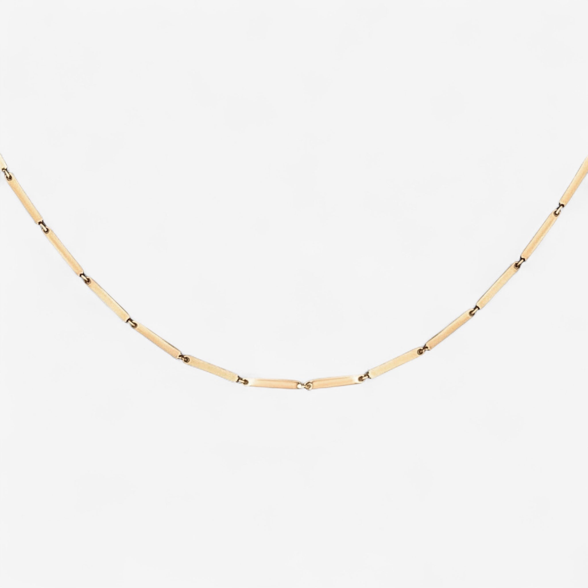 The Emmie Necklace features a delicate 14k gold plated chain with evenly spaced, elongated rectangular links for a minimalist look, shown on a plain white background.