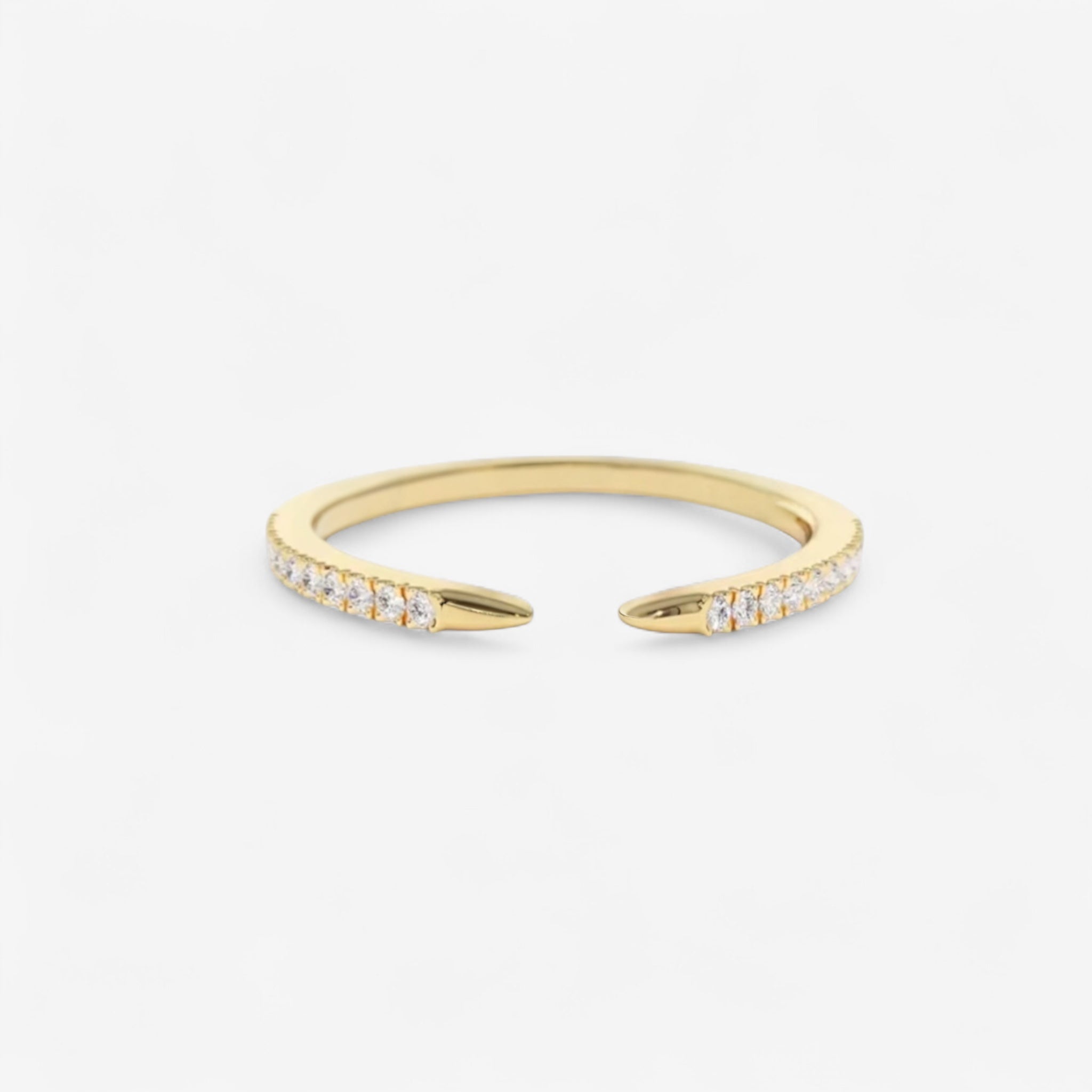 The Chloe Claw Ring is a delicate gold ring with tapered ends, each side set with small white gemstones—ideal for stacking and shown here on a plain white background.