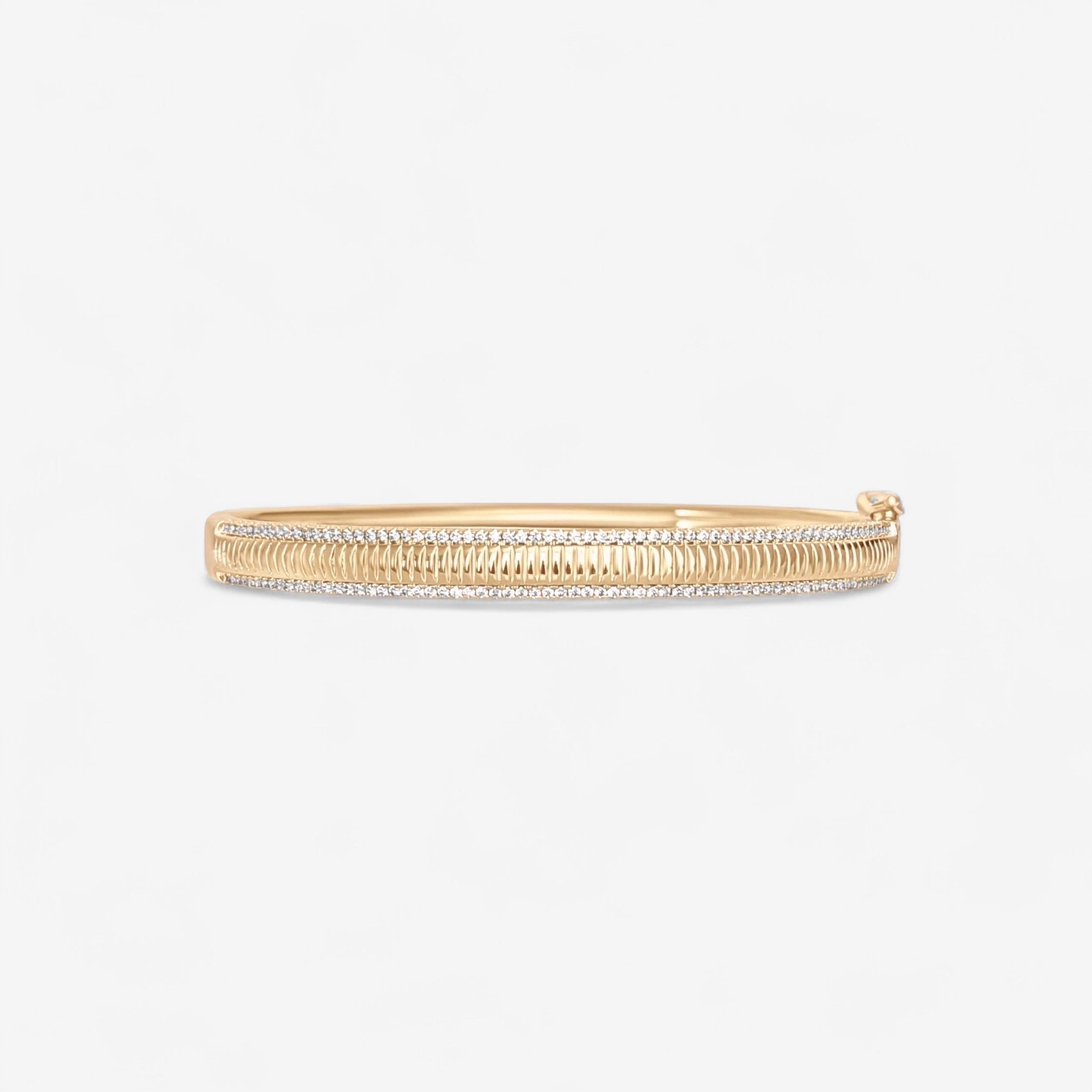 The Alyssa Fluted Bangle is a 14k gold plated bracelet with intricate center and edge detailing, featuring micro pave simulated diamonds, set against a plain white background.