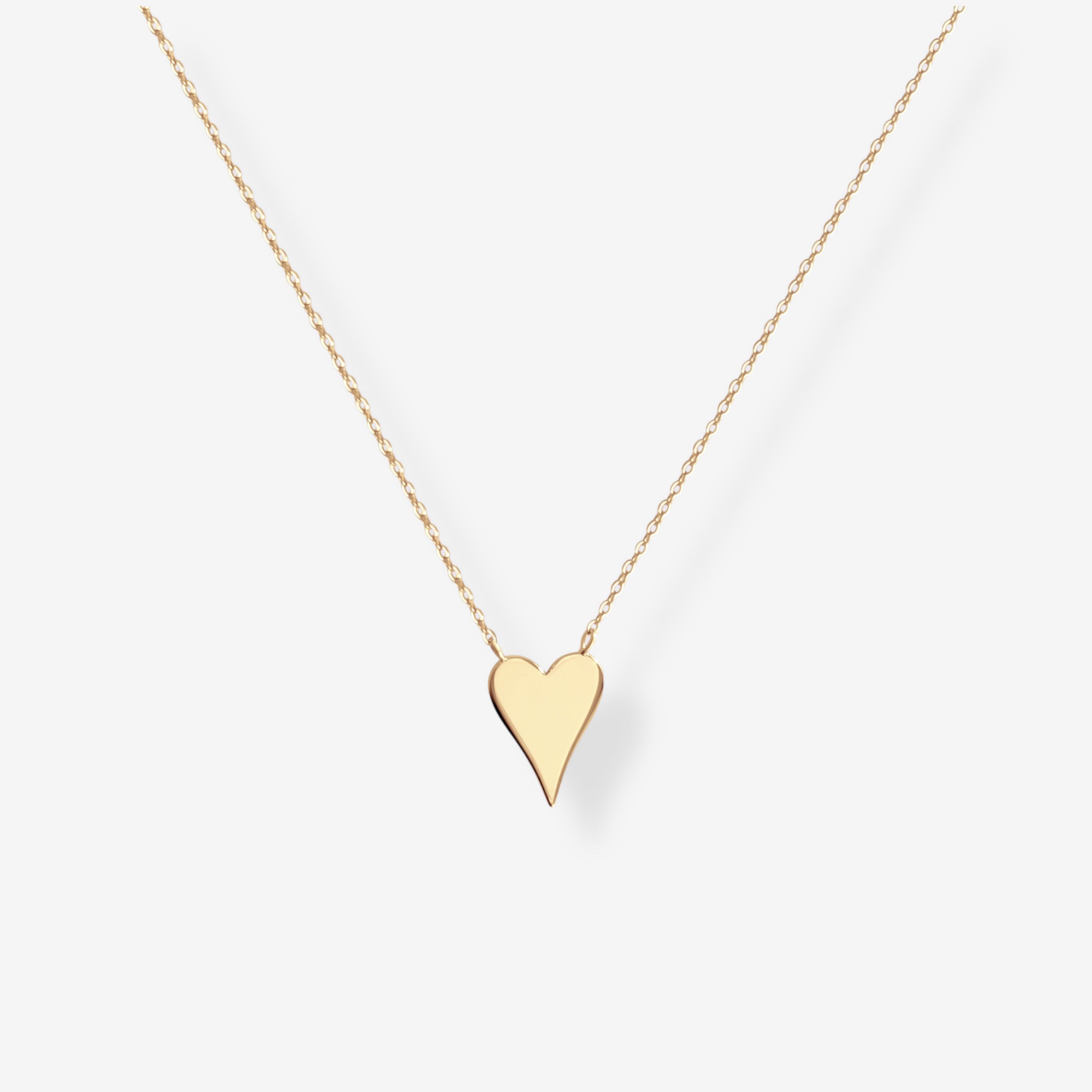The Terry Heart Pendant Necklace features a delicate gold chain with a simple, polished heart-shaped pendant displayed on a plain white background.