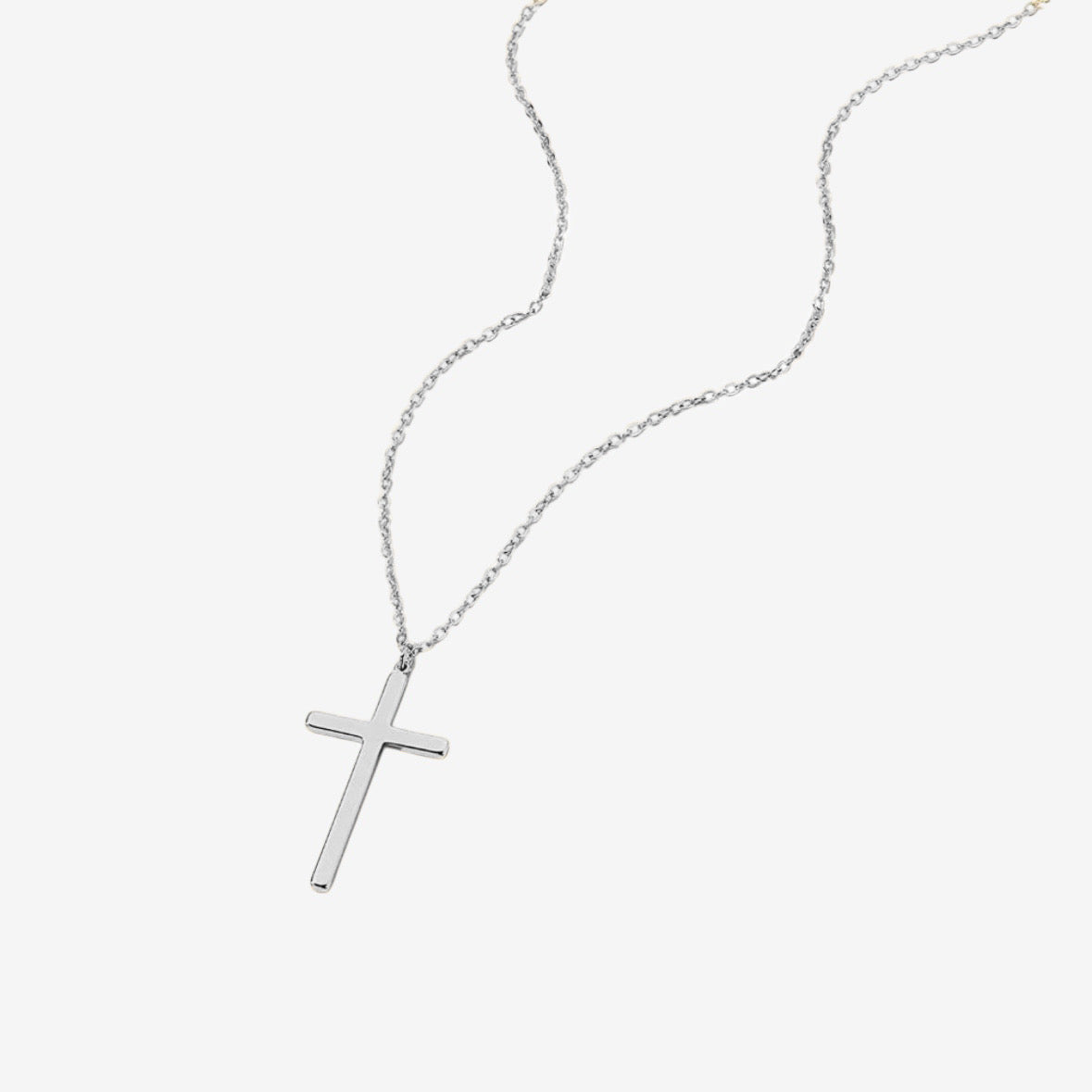 The Classic Cross Necklace, featuring a sterling silver chain and a polished cross pendant, is elegantly displayed on a white background.