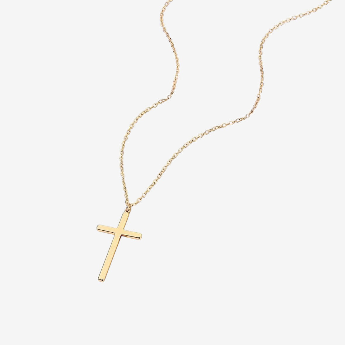 The Classic Cross Necklace – Gold features a simple gold cross pendant on a fine chain, shown against a plain white background.