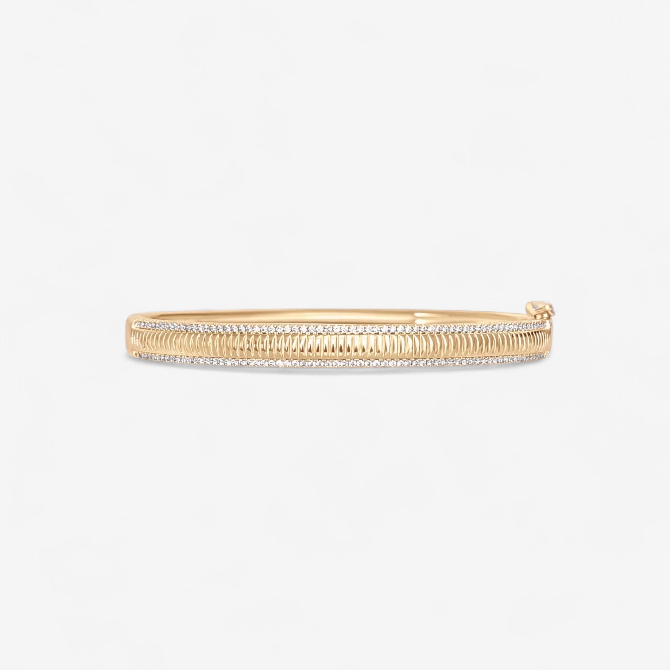 The Alyssa Fluted Bangle is a gold bracelet featuring a fluted, textured design with micro pave simulated diamonds and a clasp, shown against a plain white background.