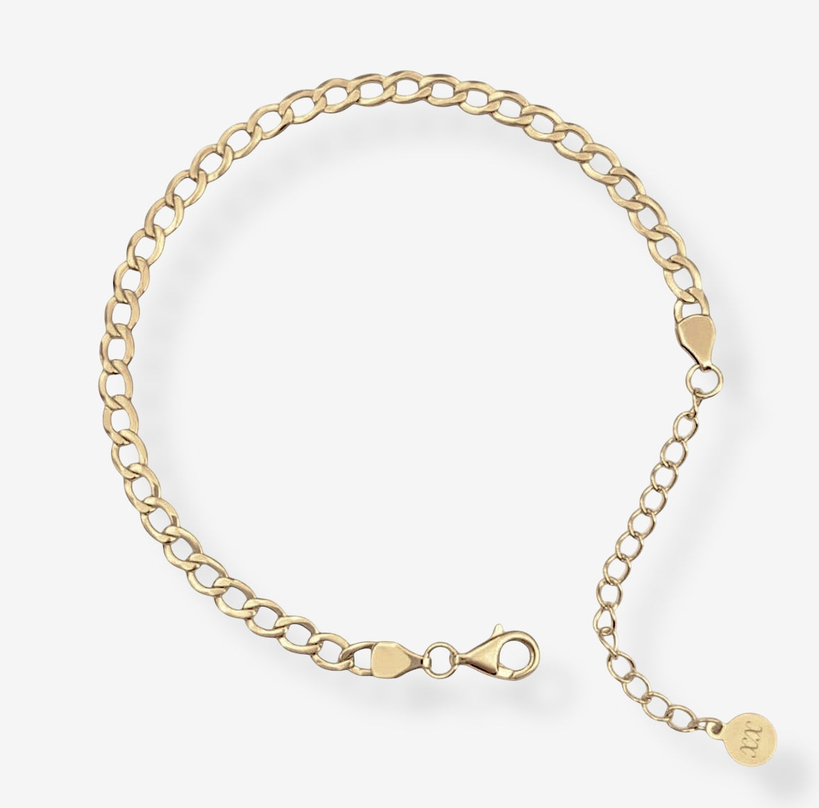 The Brynn Cuban Bracelet is a delicate 14k gold-plated chain with flat oval links, a lobster clasp, and an adjustable extension finished with a small round charm. Shown against a plain white background.