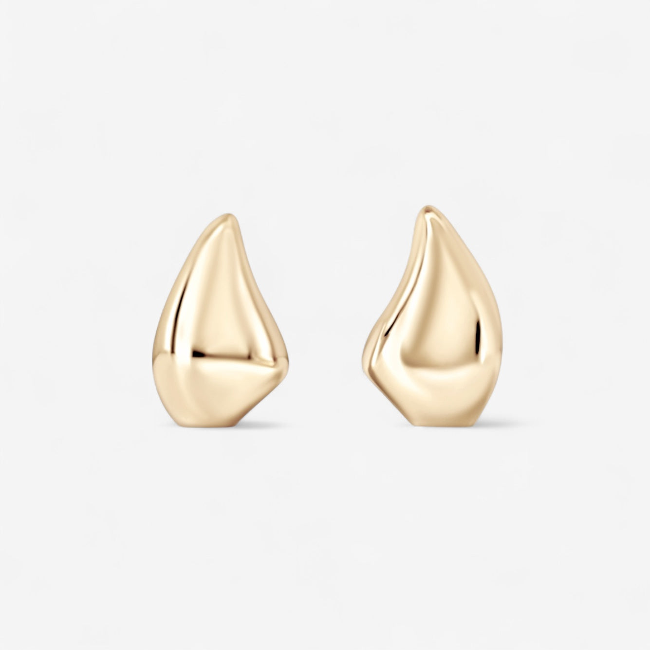 The Demi Teardrop Earrings feature an abstract, gold-toned design with smooth, asymmetrical shapes—ideal for everyday wear—shown on a plain white background.