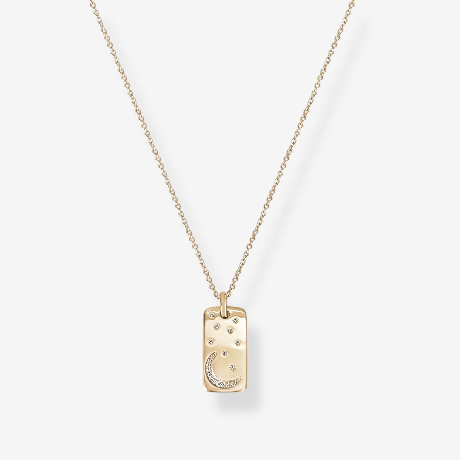 The Moonlight Pendant Necklace is a gold necklace with a rectangular pendant featuring a crescent moon and star, accented by clear stones on a white background.
