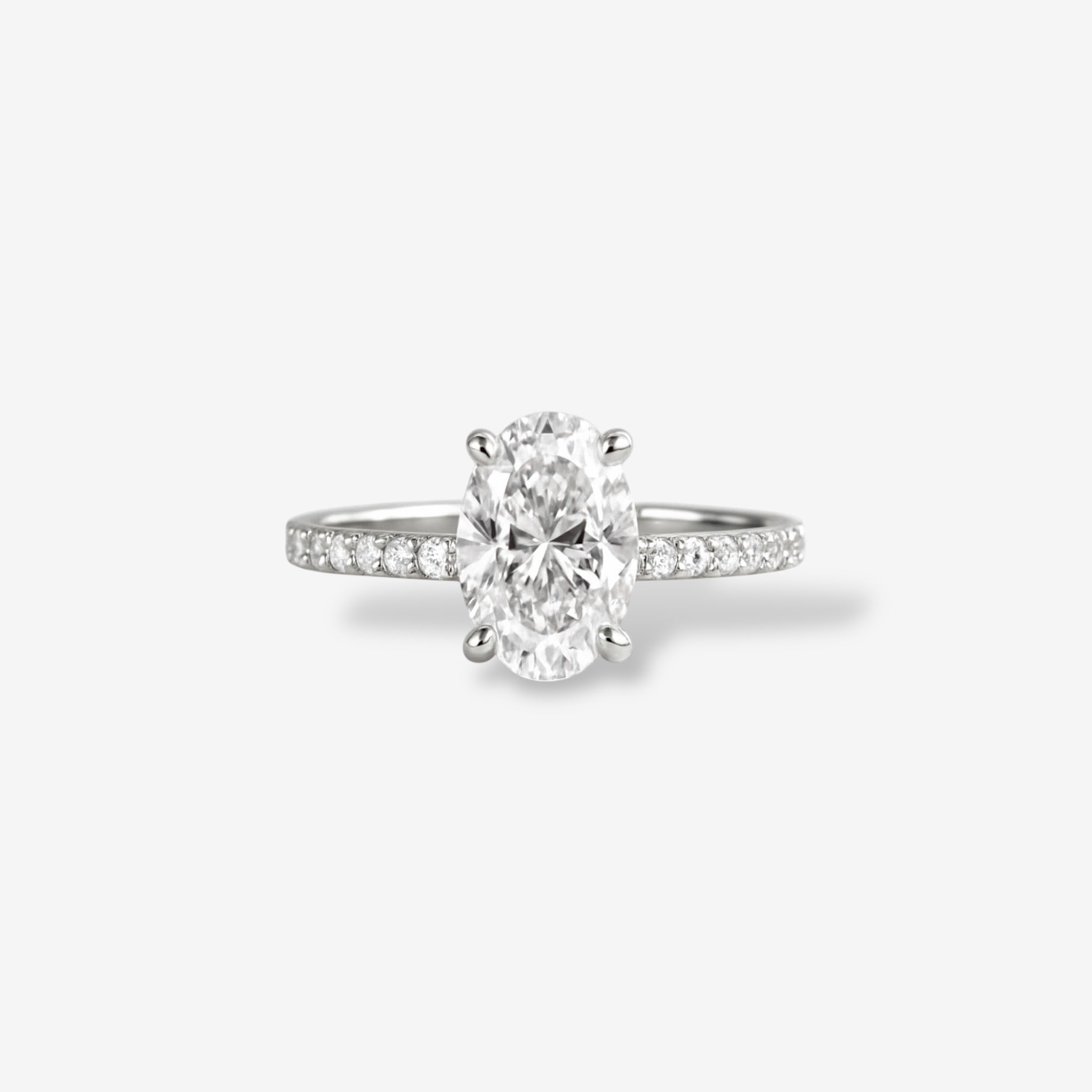 The Olivia Sparkle Ring showcases an oval-cut simulated diamond on a slim 18k white gold band with petite diamonds, set against a white background.