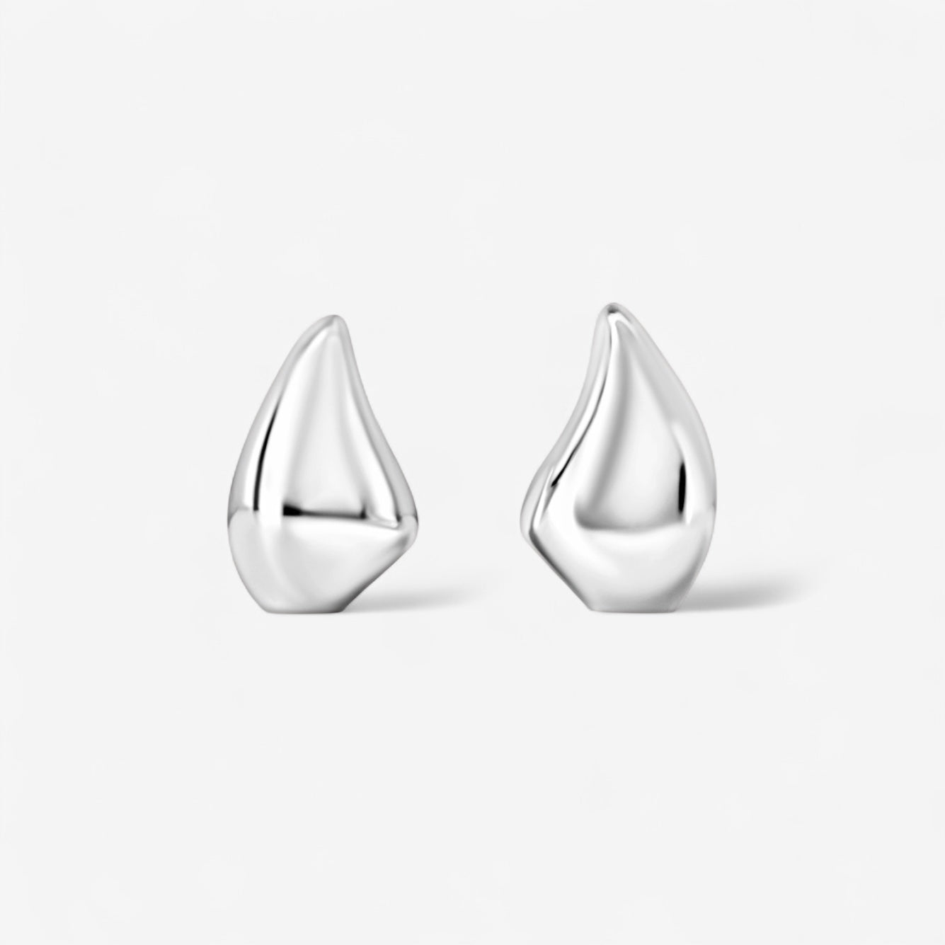 The Demi Teardrop Earrings are abstract teardrop-shaped silver earrings, ideal for everyday wear, shown against a plain white background.