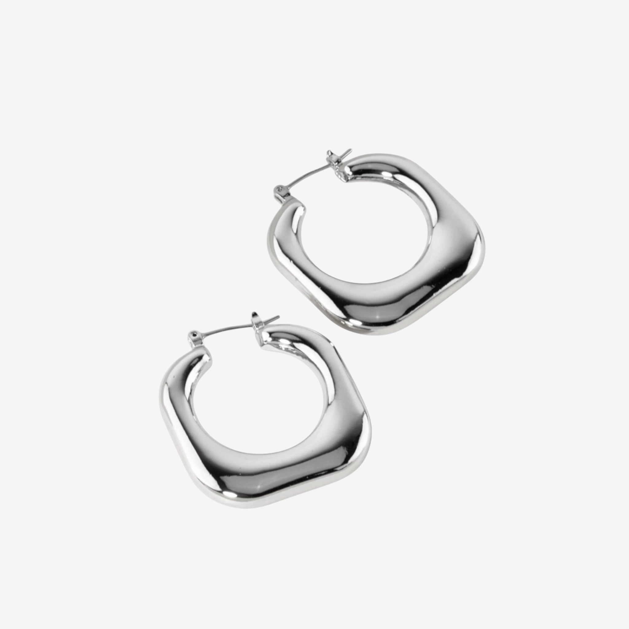 Stormy Squared Hoops: chunky, shiny hoops with a rounded square shape and rhodium plated silver finish, displayed on a plain white background.