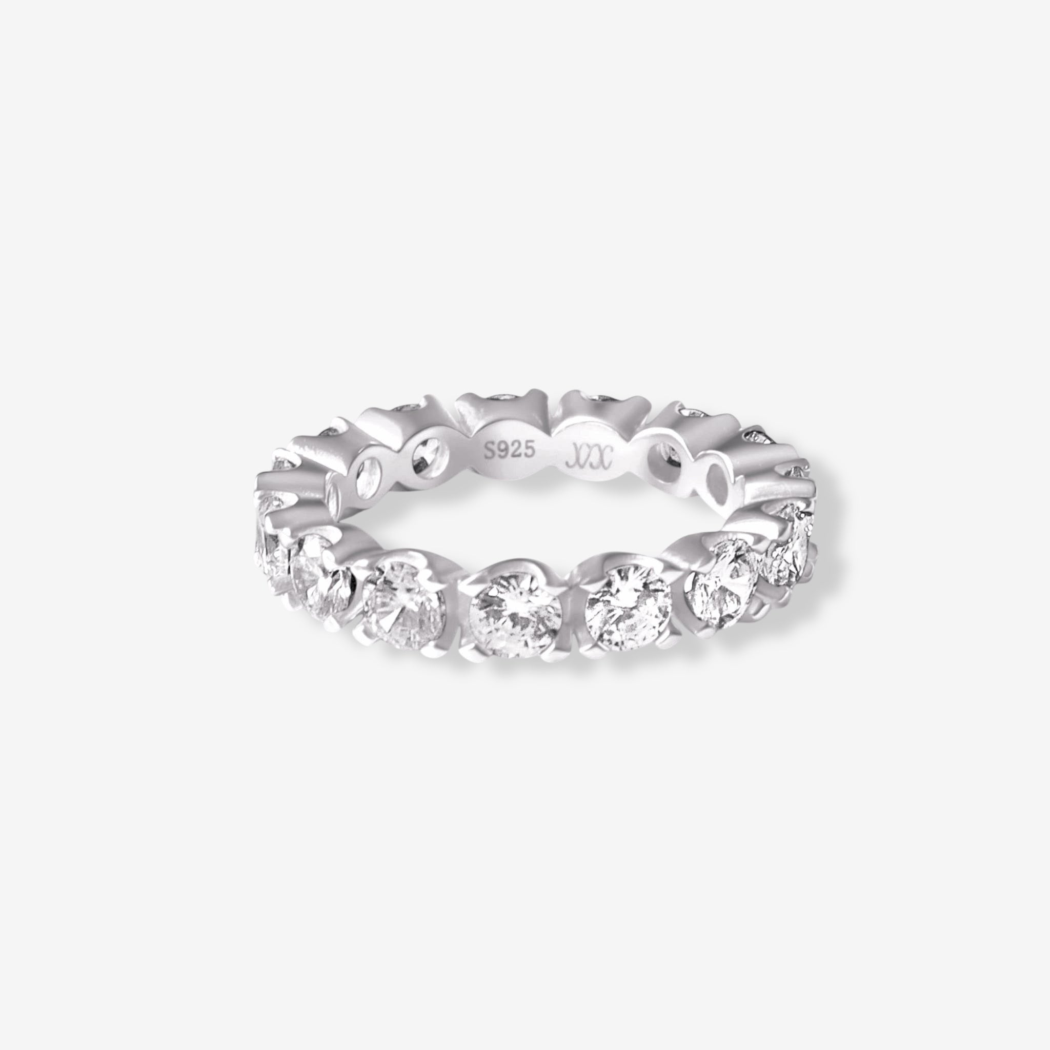 The Sydney Ring is a sterling silver eternity band with round-cut simulated diamonds all around, engraved with S925 inside, and shown against a white background.