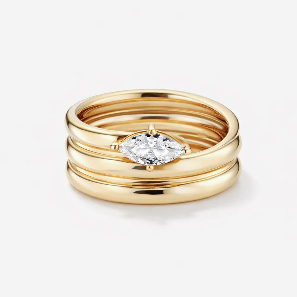 Melia Ring in gold featuring a stacked stainless steel band with a marquise cut cubic zirconia center stone