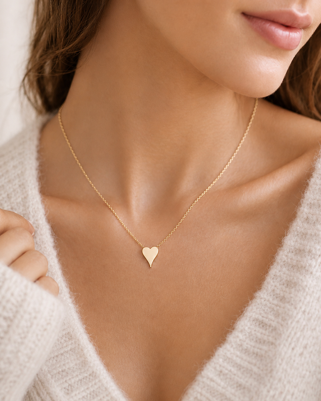 Close up of model wearing Terry gold heart pendant necklace with minimalist everyday jewelry styling